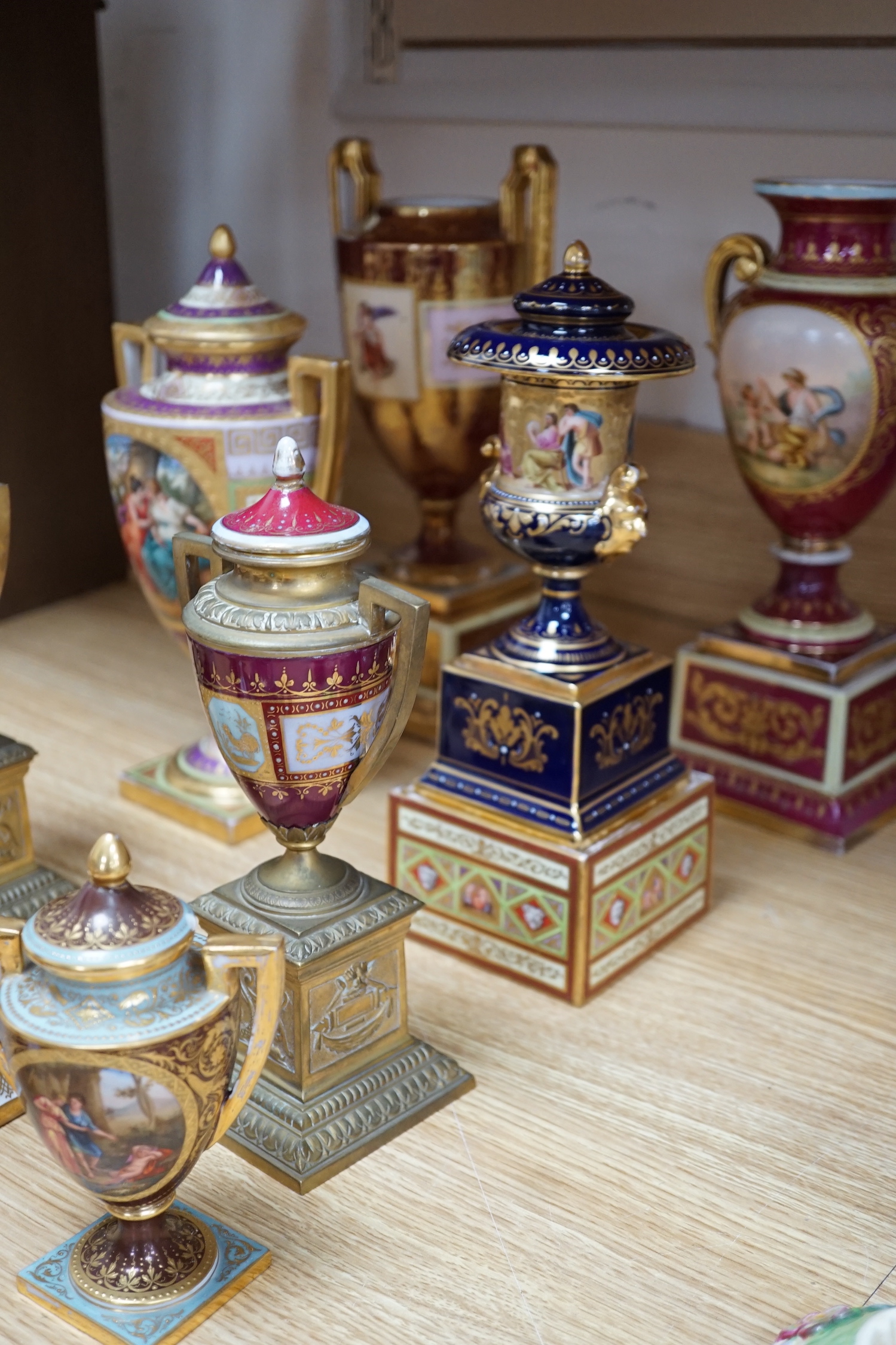 Ten Vienna type porcelain and brass pedestal vases, six with covers, largest 29cm high